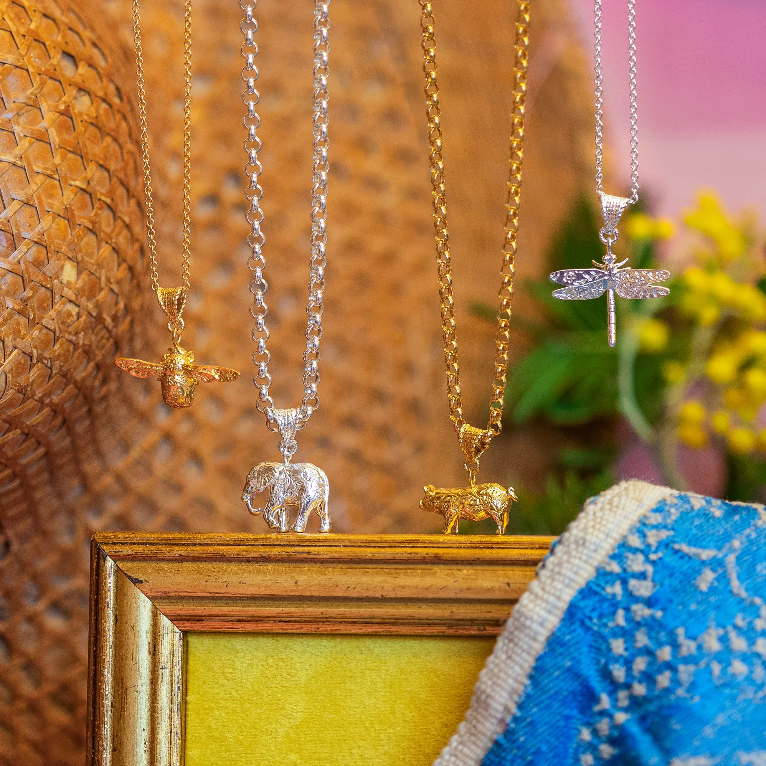 Gold and silver pendant necklaces featuring animal and insect charms including a bee, elephant and dragonfly