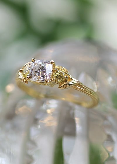 Model wearing Alex Monroe diamond halo engagement ring and Spring Halo Diamond Eternity band